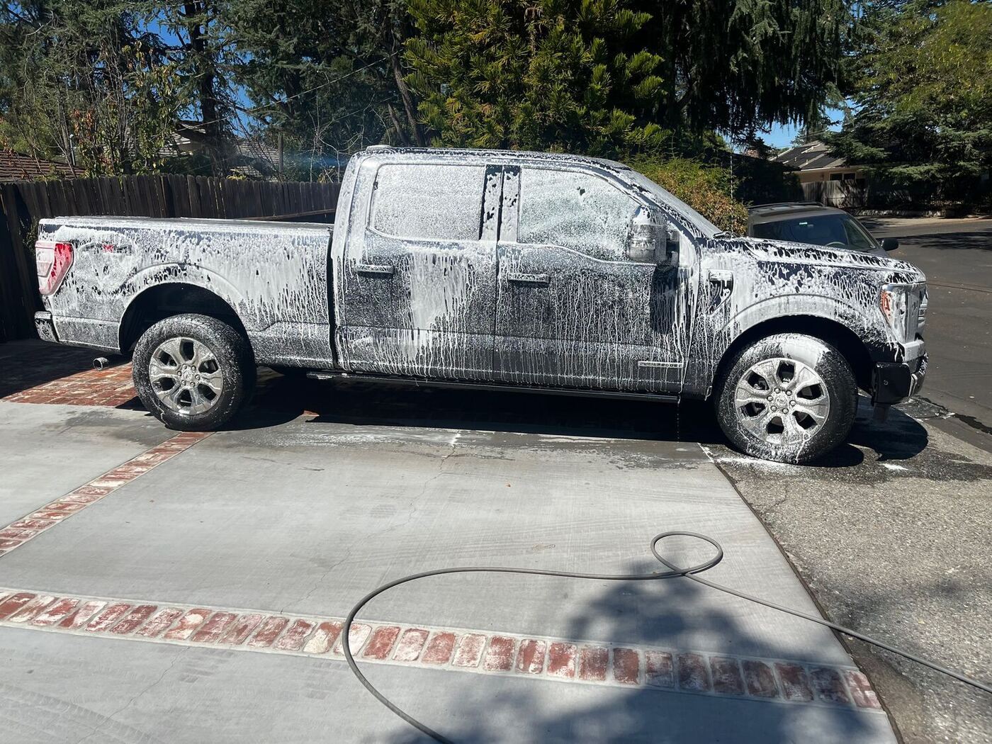 Ford F-150 covered in wash foam in a driveway