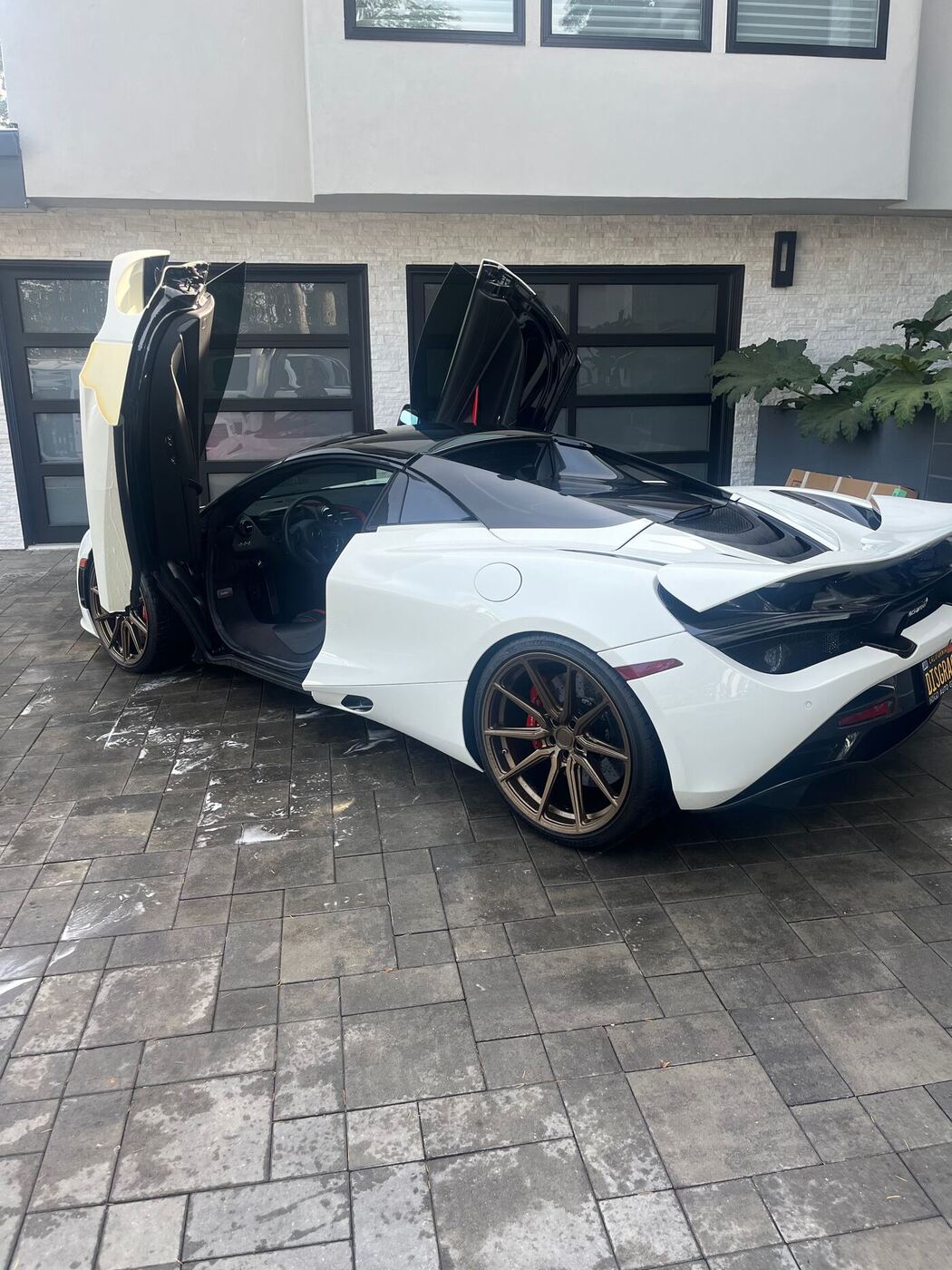White McLaren 720S with dihedral doors open after detailing